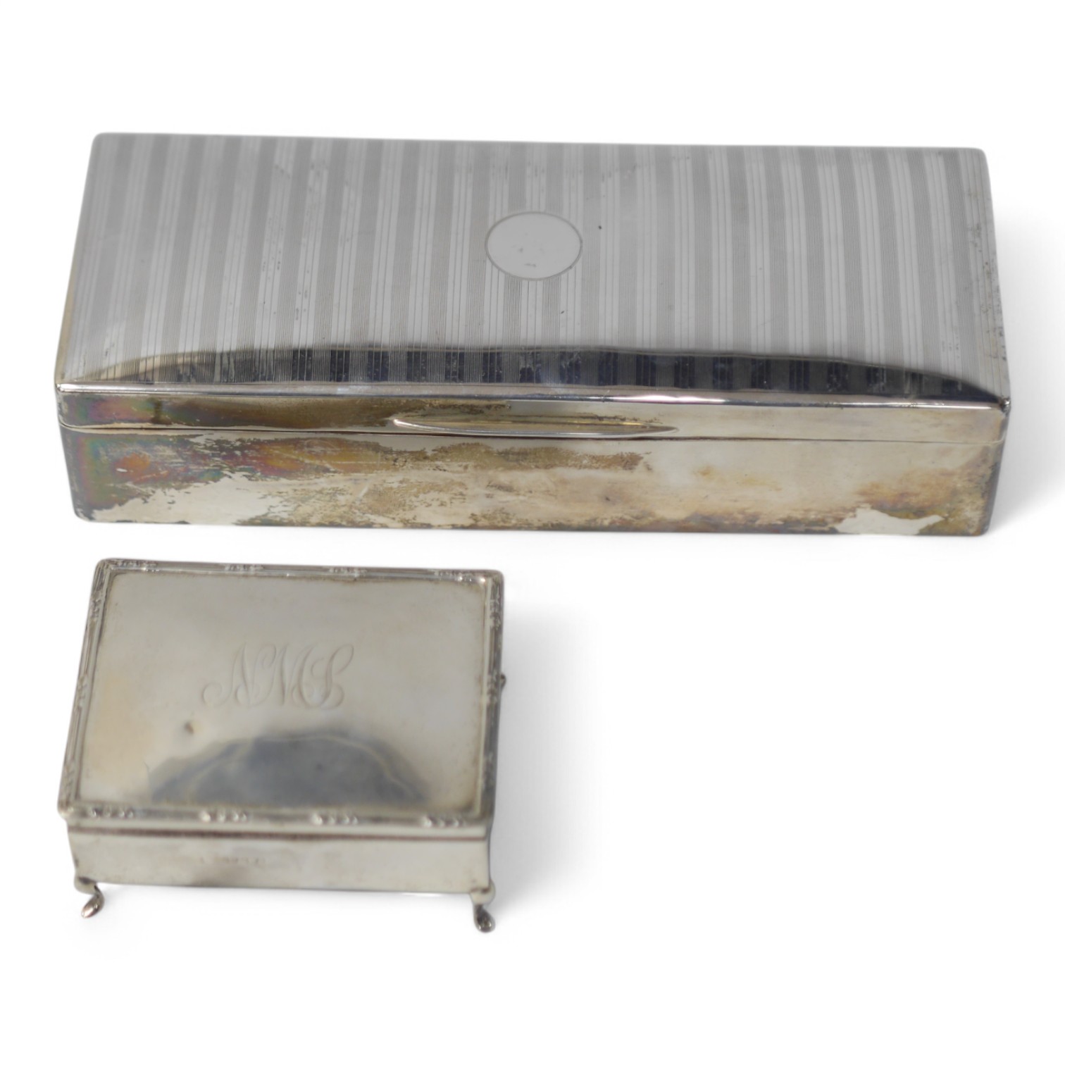 A George V silver mounted rectangular cigarette box, London, 1926, 25.9cm, together with an Edwardian silver mounted cigarette box (ex trinket box?). Condition - fair